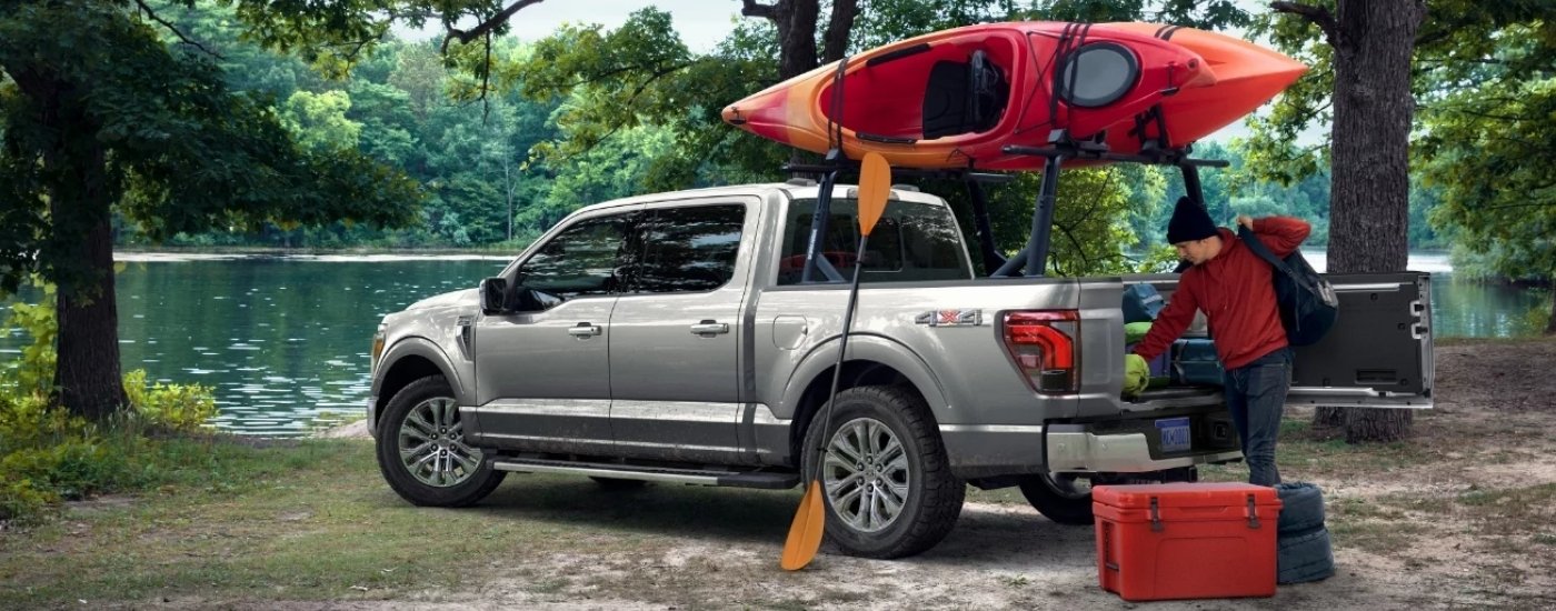 Person unloading gear from a tan 2024 Ford F-150 for sale near Clermont